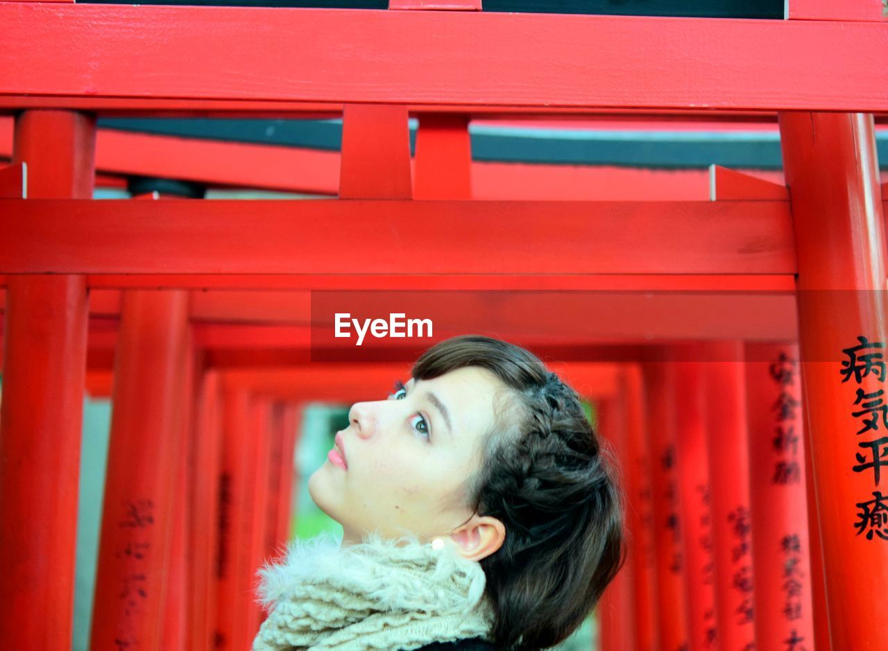 Portrait of a young woman looking away japanese girl at torii gate 