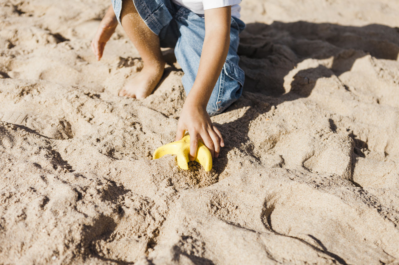 Low section of child on sandy beach