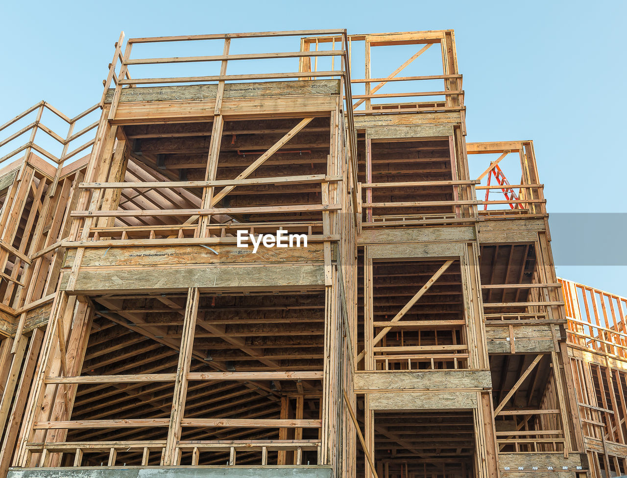 LOW ANGLE VIEW OF CRANE AGAINST BUILDING
