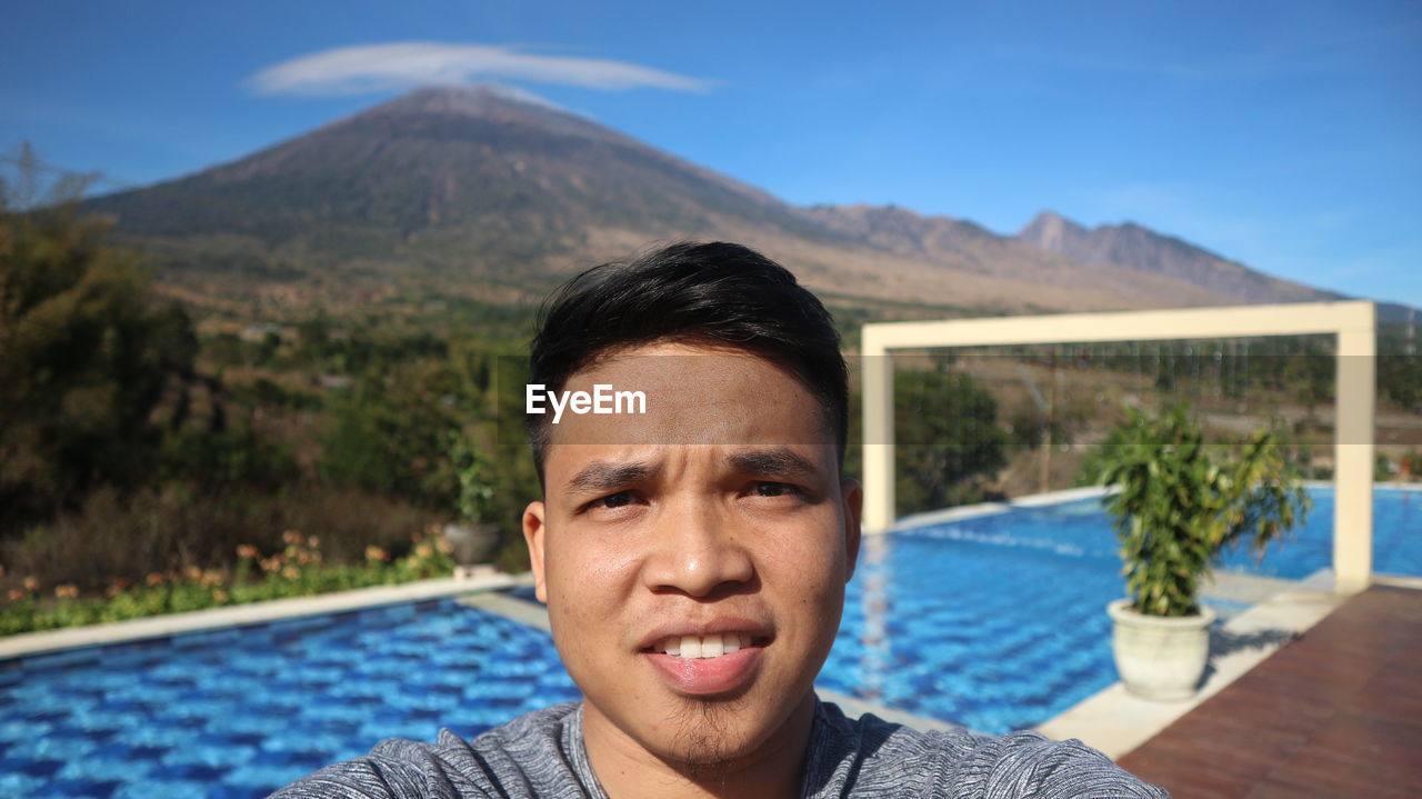 Portrait of young man against mountains