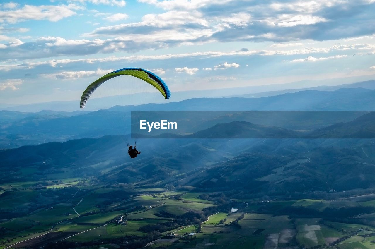 Scenic view of person paragliding against sky