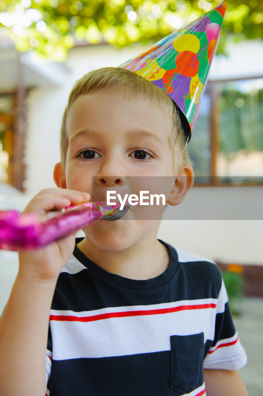 Portrait of cute boy holding camera