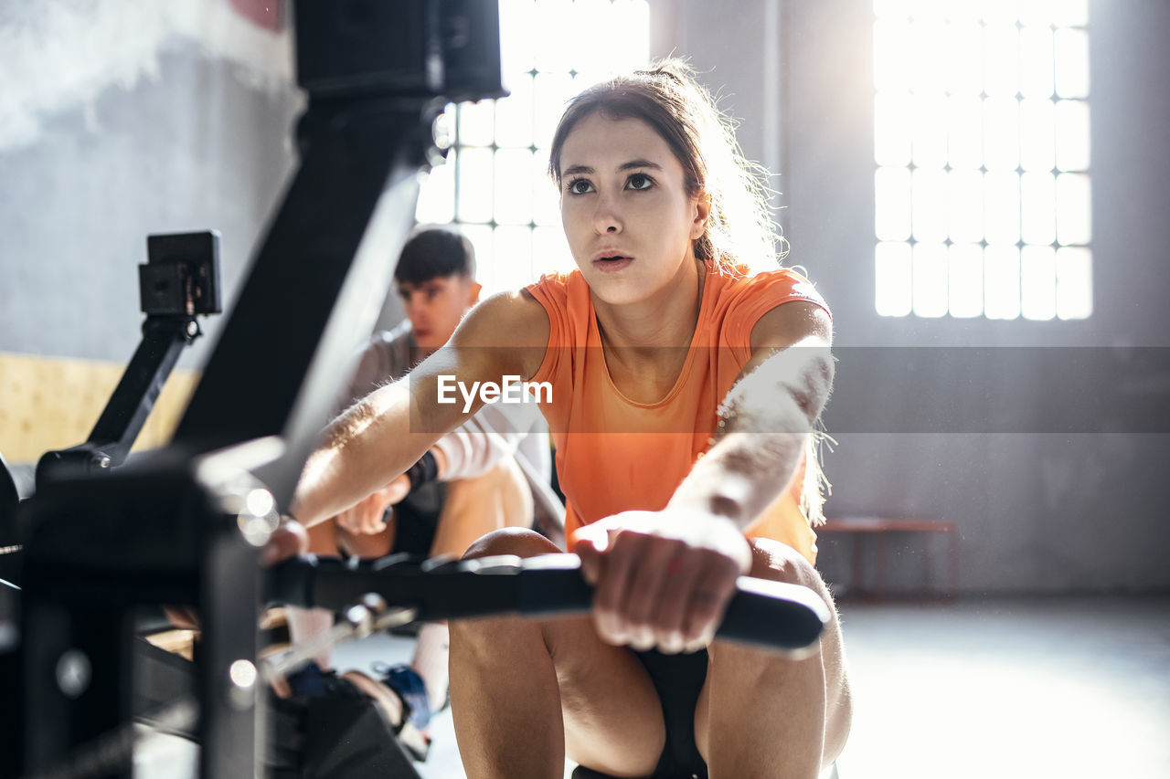 Young man and woman exercising at gym