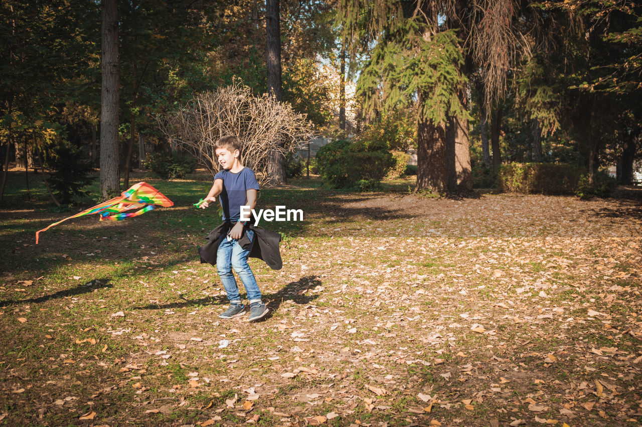 Full length of boy playing kite in park