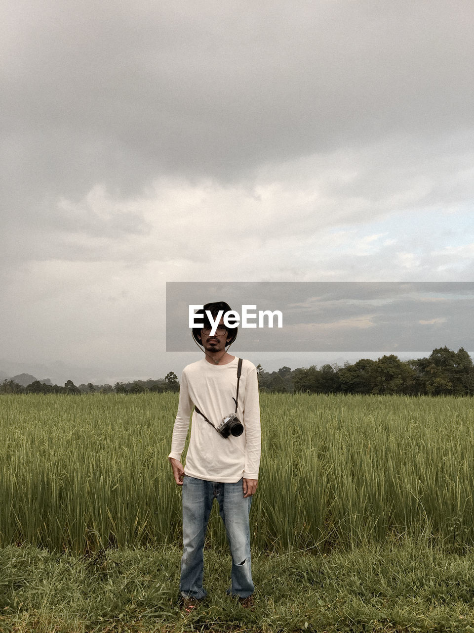 MAN STANDING ON FIELD AGAINST SKY