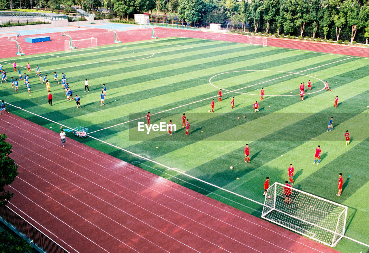 HIGH ANGLE VIEW OF PEOPLE PLAYING SOCCER