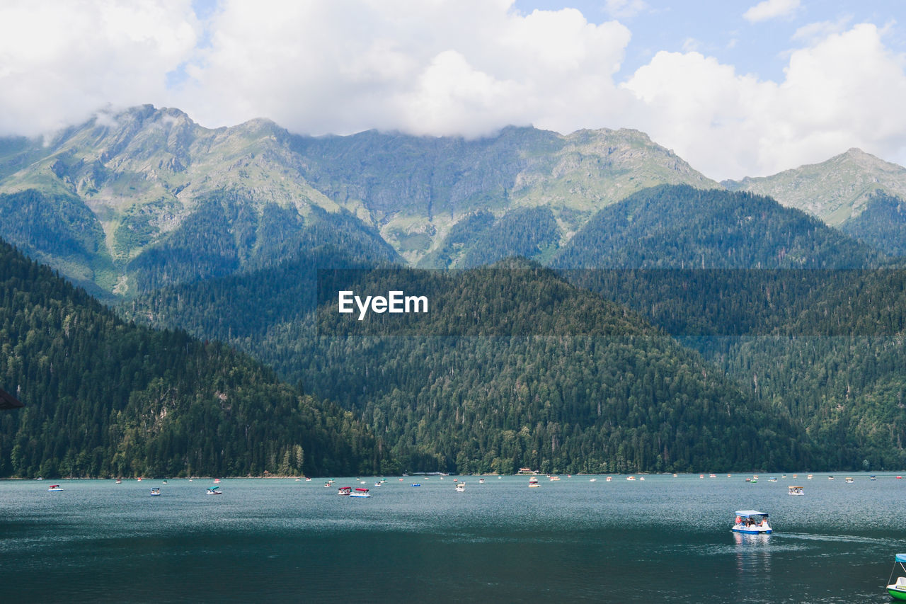 Scenic view of lake by mountains against sky