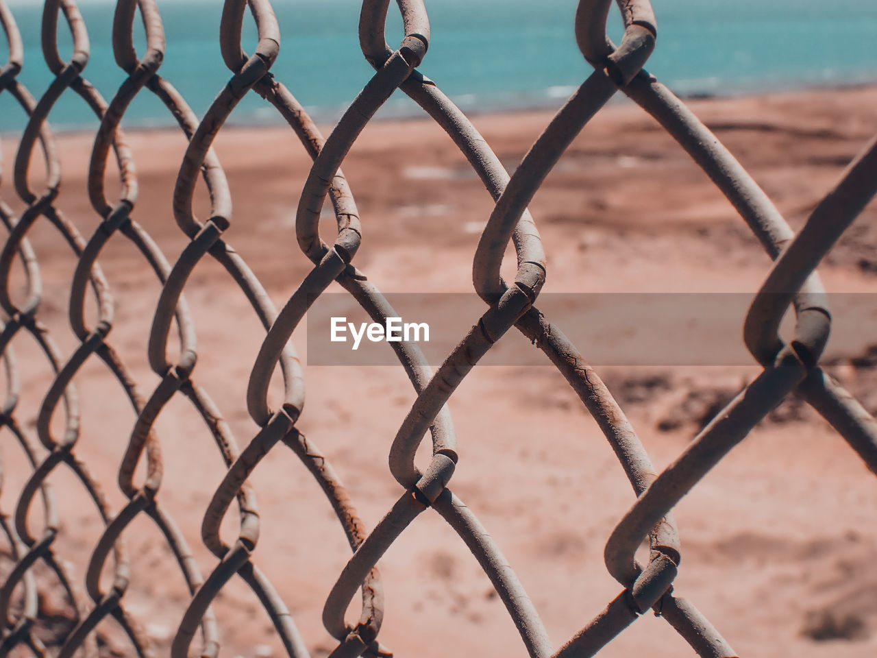 FULL FRAME SHOT OF CHAINLINK FENCE IN SEA