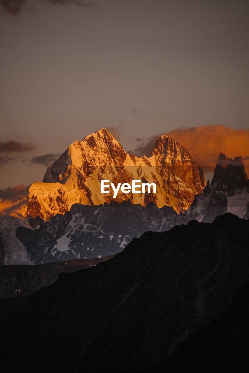 Scenic view of snowcapped mountains against sky during sunset