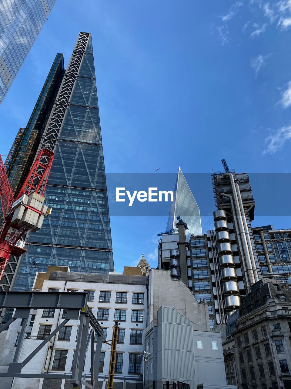 Low angle view of modern buildings against blue sky in the city of london