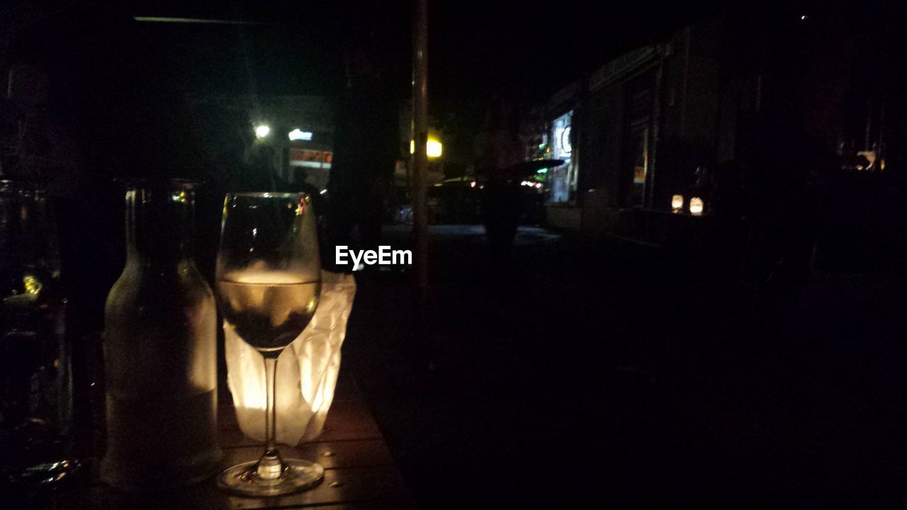 White wine on illuminated table at night