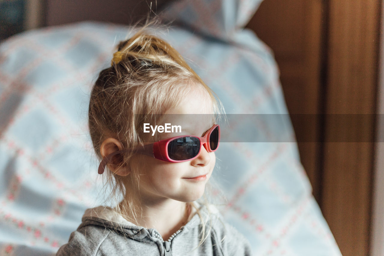 Close-up of smiling cute girl wearing sunglasses