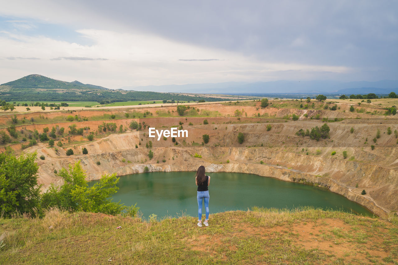 MAN STANDING ON LANDSCAPE AGAINST SKY