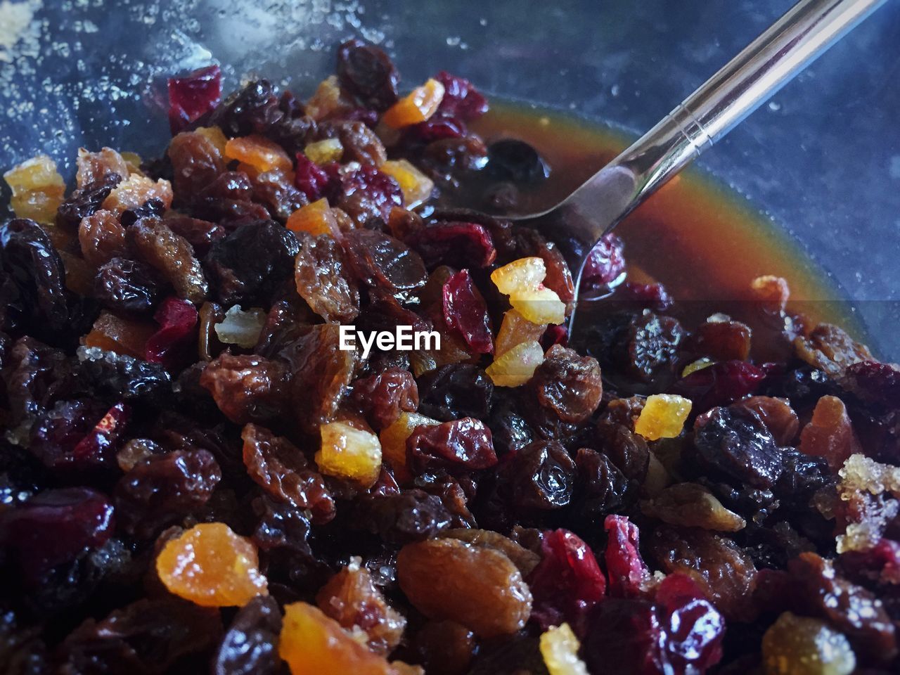 Macro shot of raisin in bowl with spoon