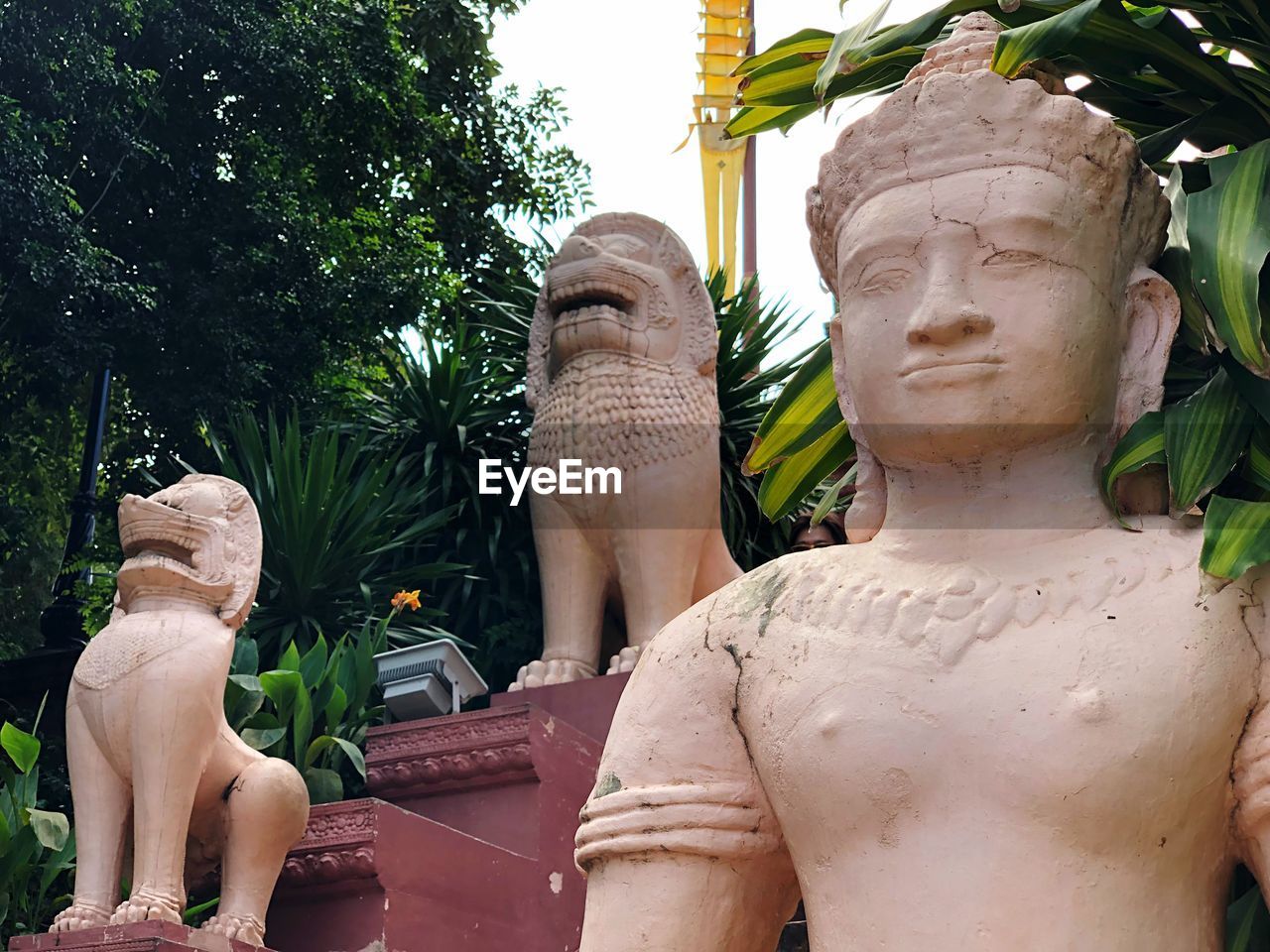 Low angle view of statues against trees