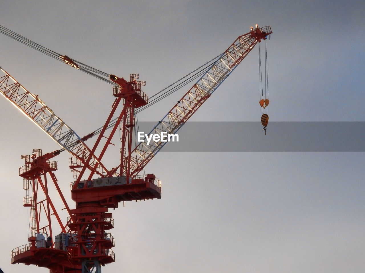 Low angle view of cranes against sky