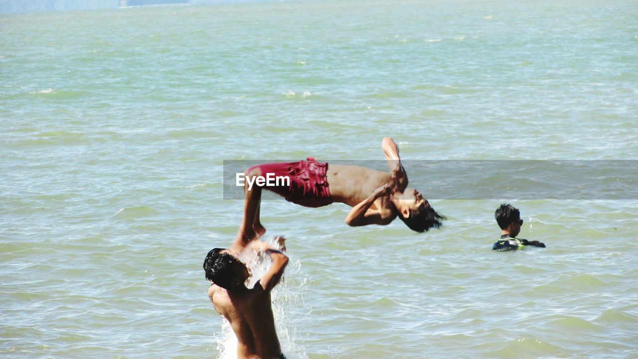 High angle view of men enjoying summer in sea