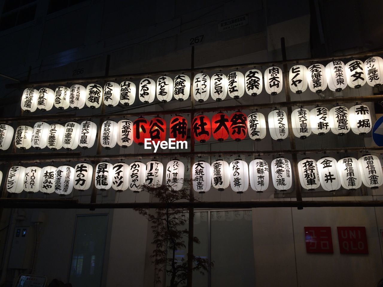 Illuminated japanese lantern hanging by building