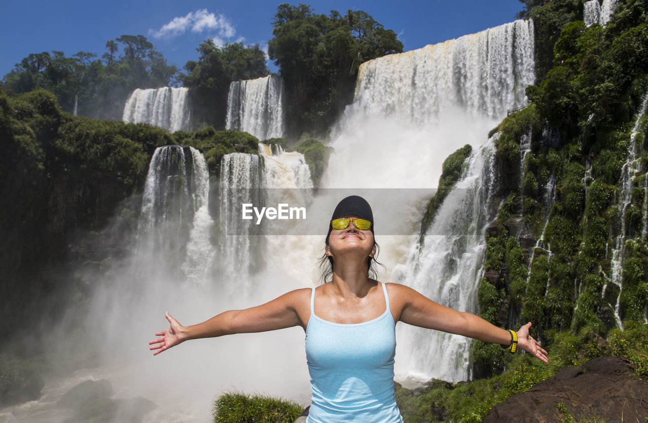 Woman posing in front of iguazu waterfalls