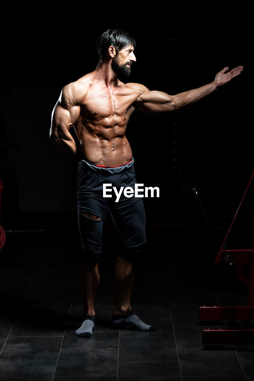 rear view of shirtless man standing in gym