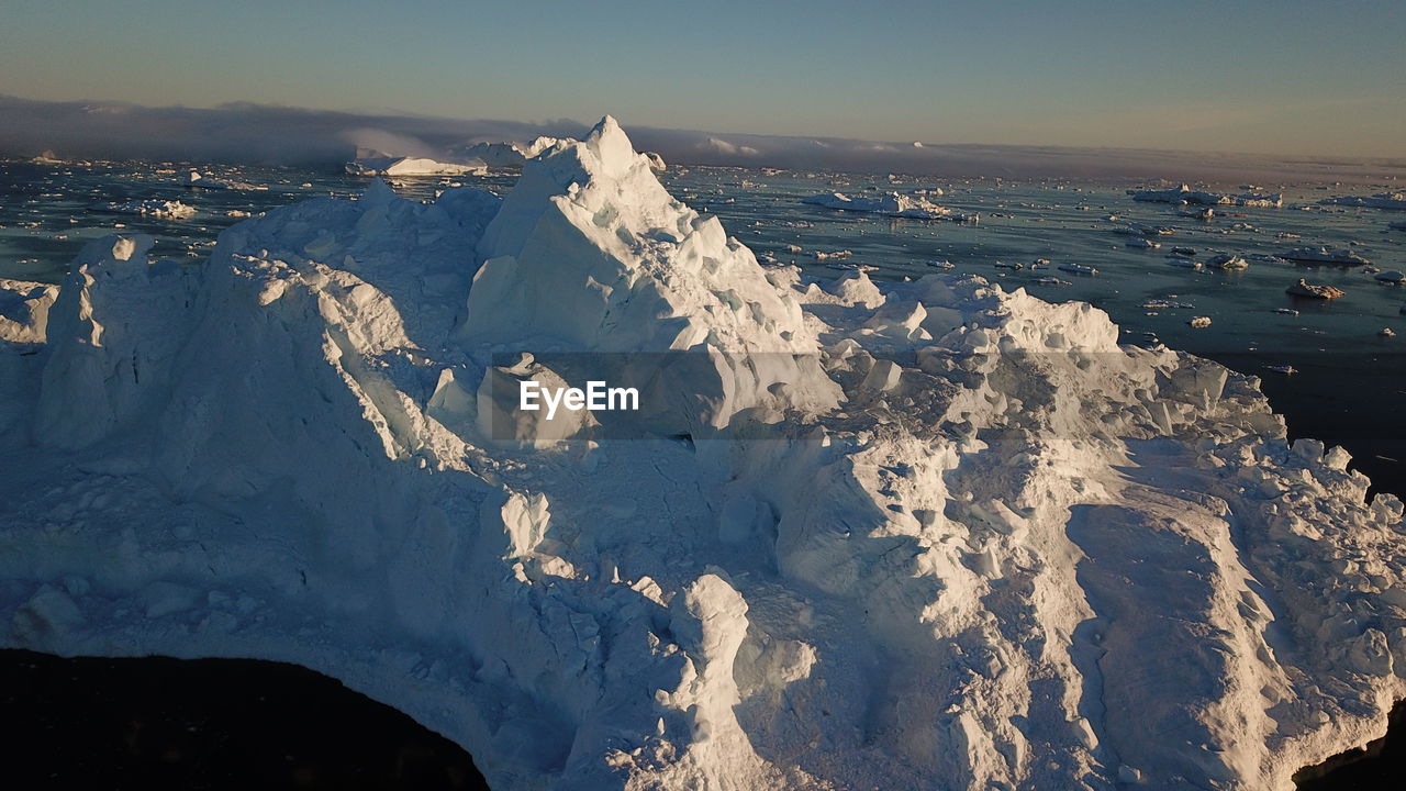 AERIAL VIEW OF SNOW COVERED MOUNTAIN AGAINST SKY