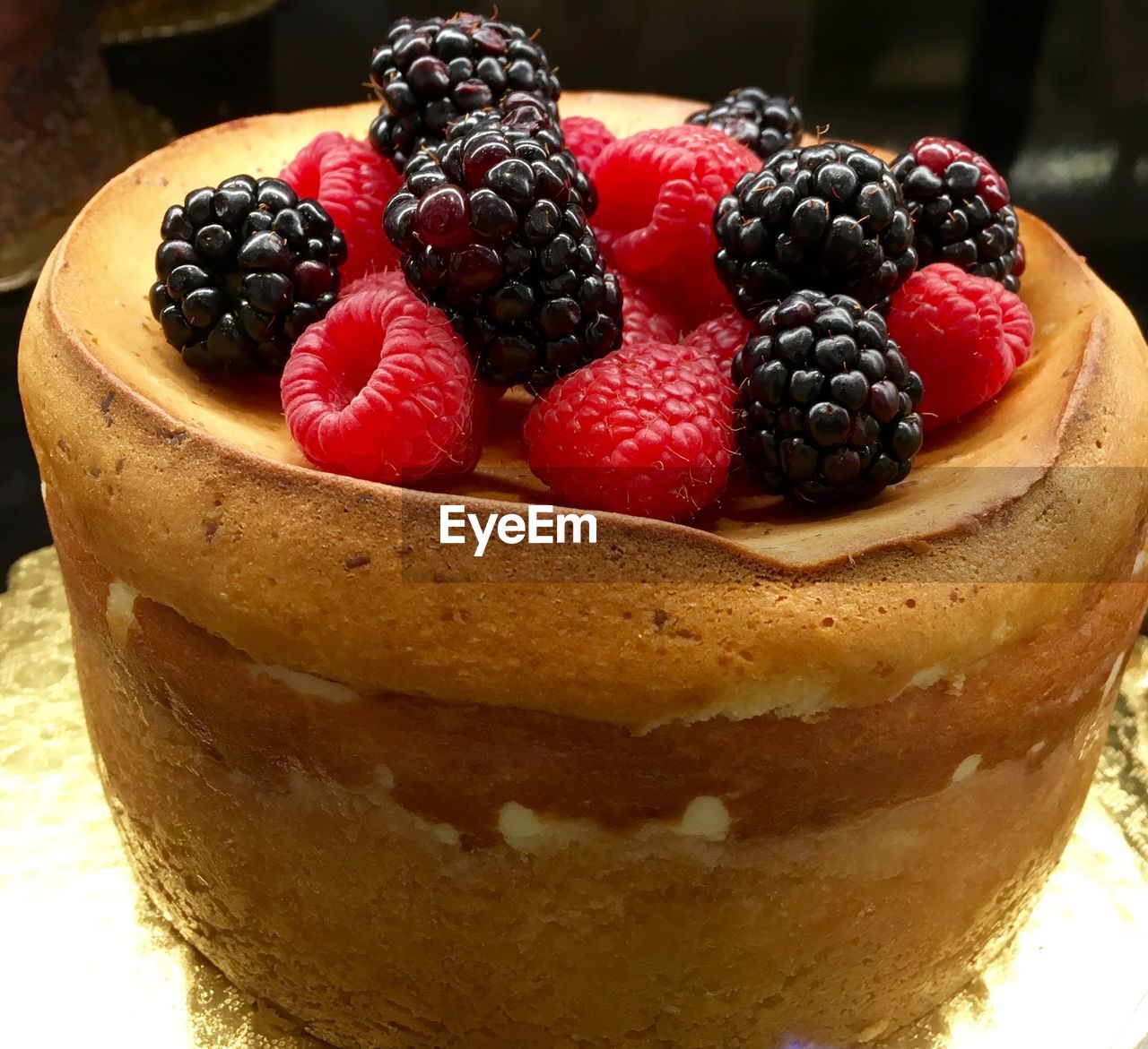 Close-up of cake garnished with raspberries and blackberries