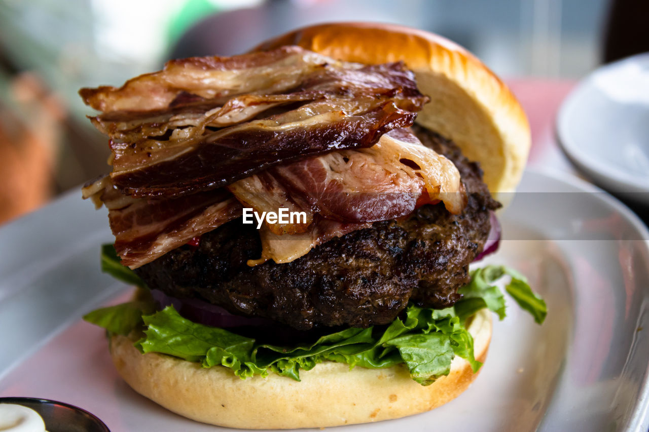 Close up of bacon strips on a burger patty in a burger