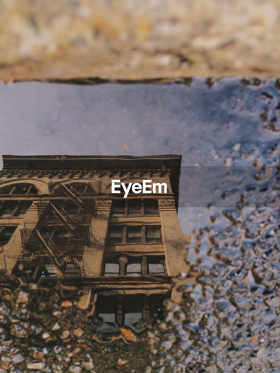 High angle view of building reflection in puddle