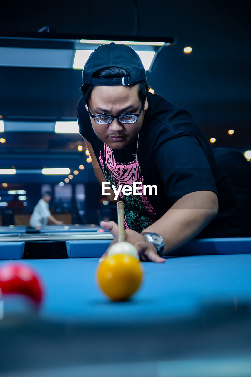 portrait of young woman playing pool