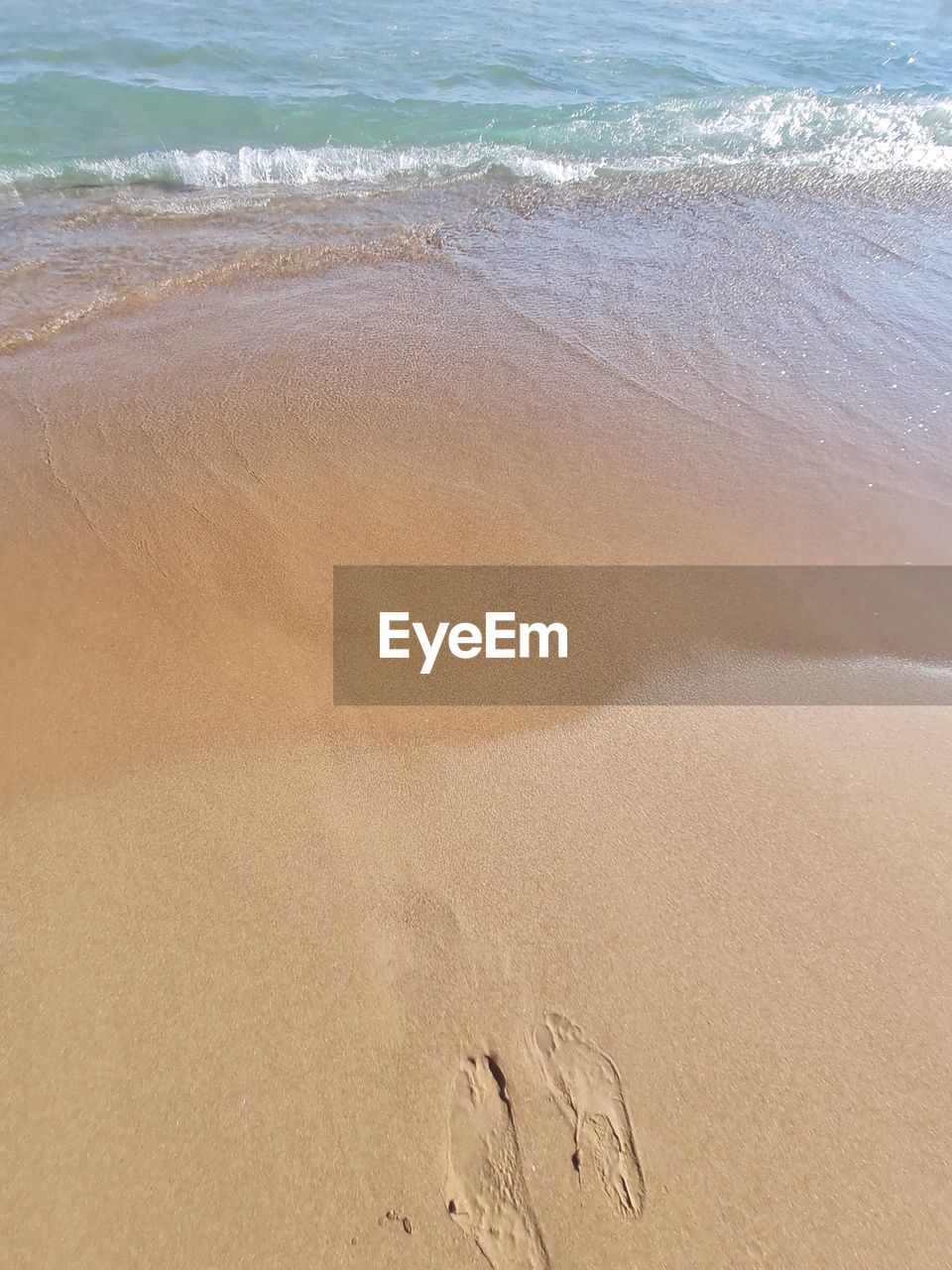 HIGH ANGLE VIEW OF FOOTPRINT ON BEACH