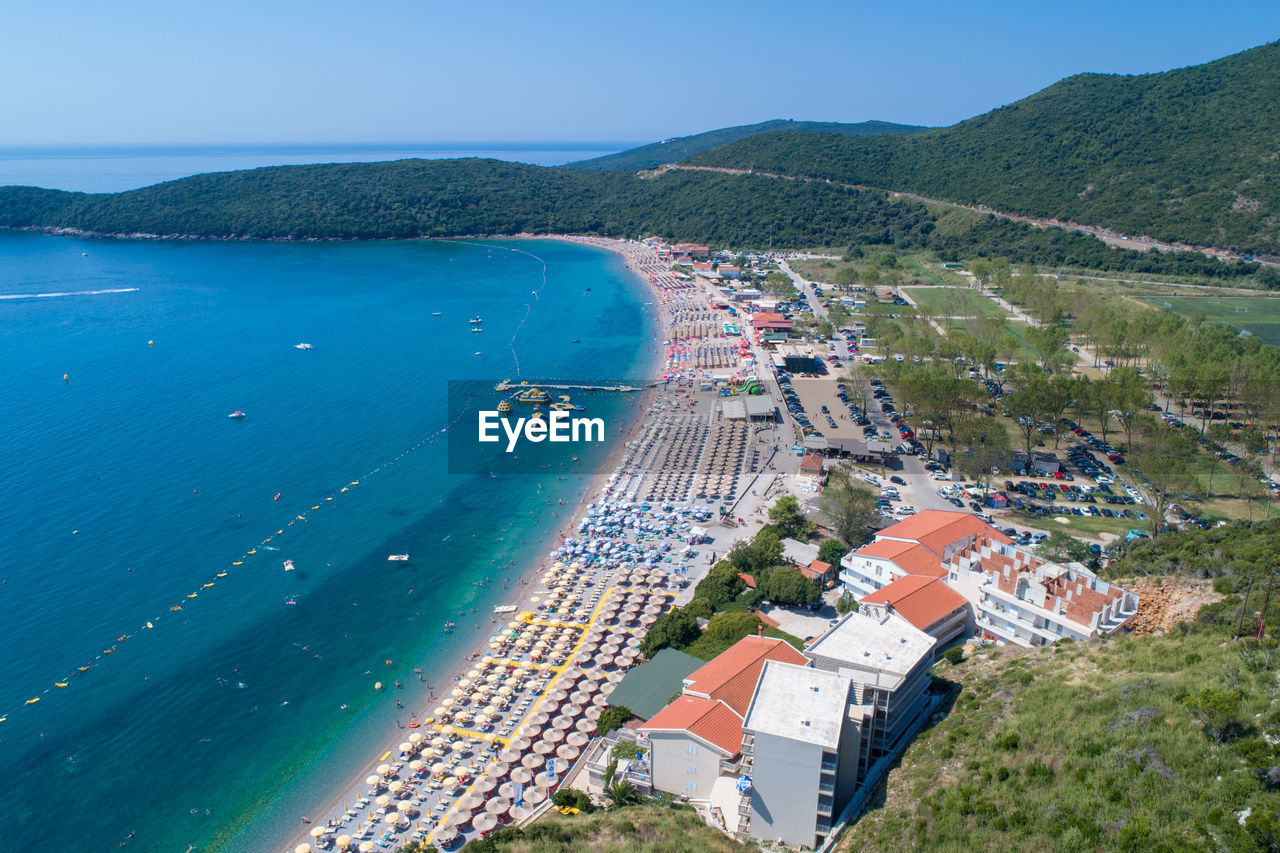 HIGH ANGLE VIEW OF SEA AND BUILDINGS IN CITY