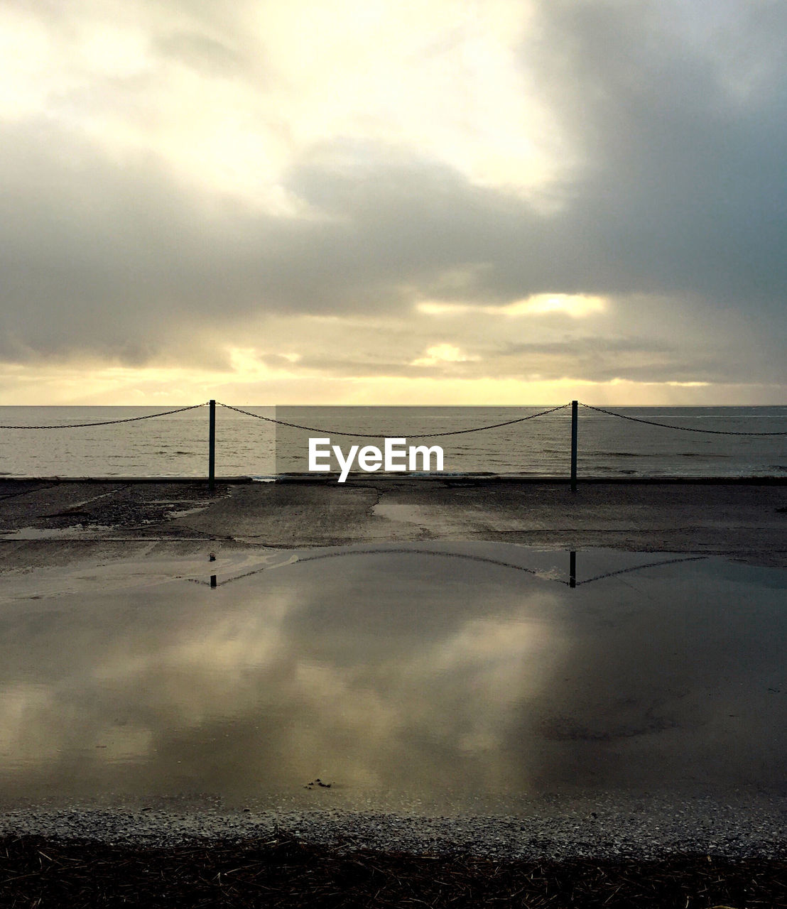 Scenic view of calm sea against cloudy sky