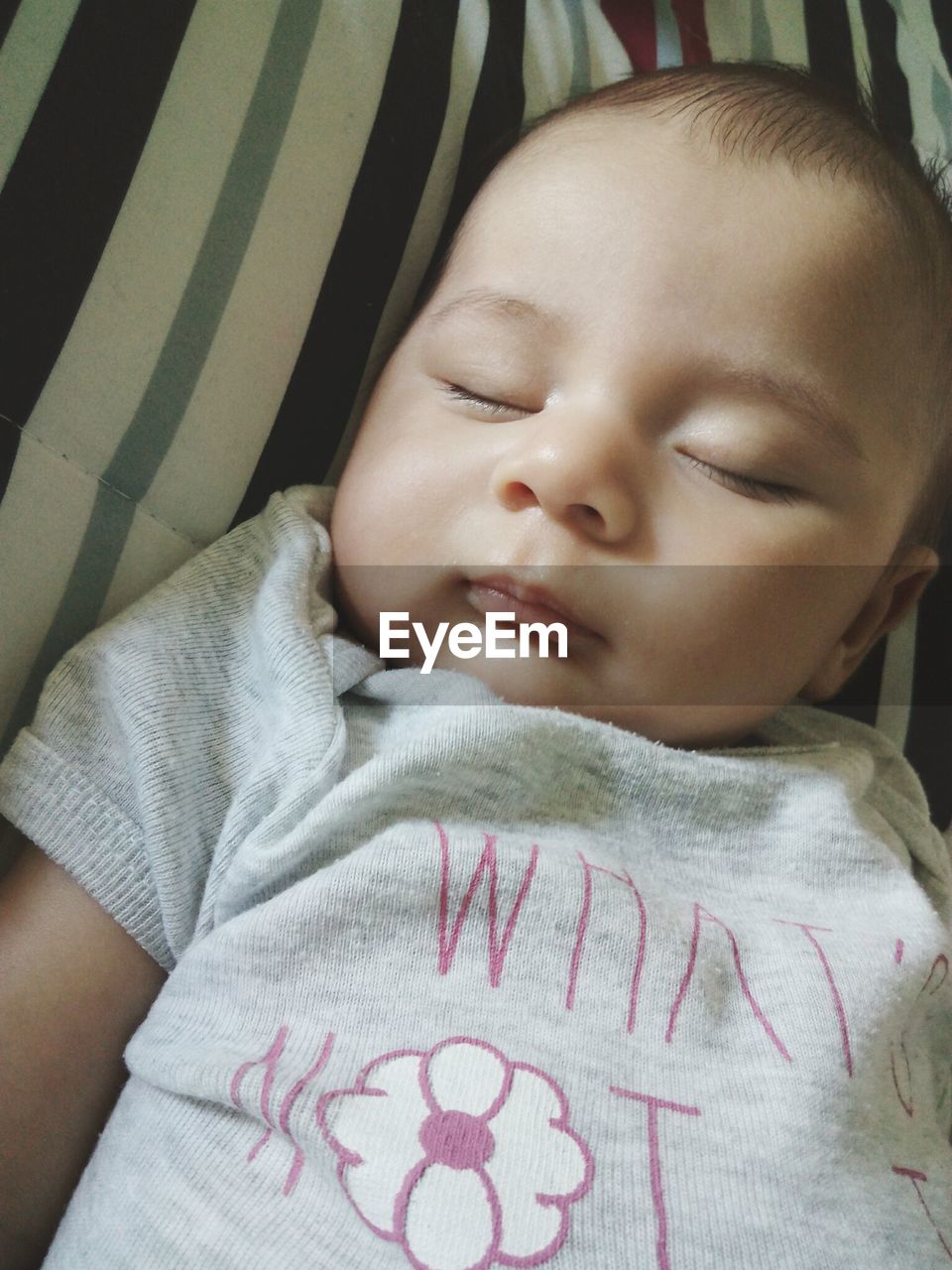 Close-up of cute baby boy sleeping on bed