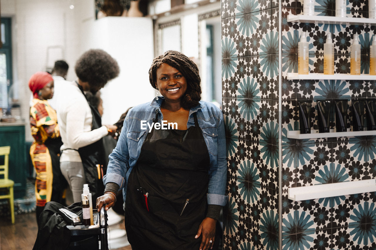Portrait of smiling mature female hairdresser in barber shop