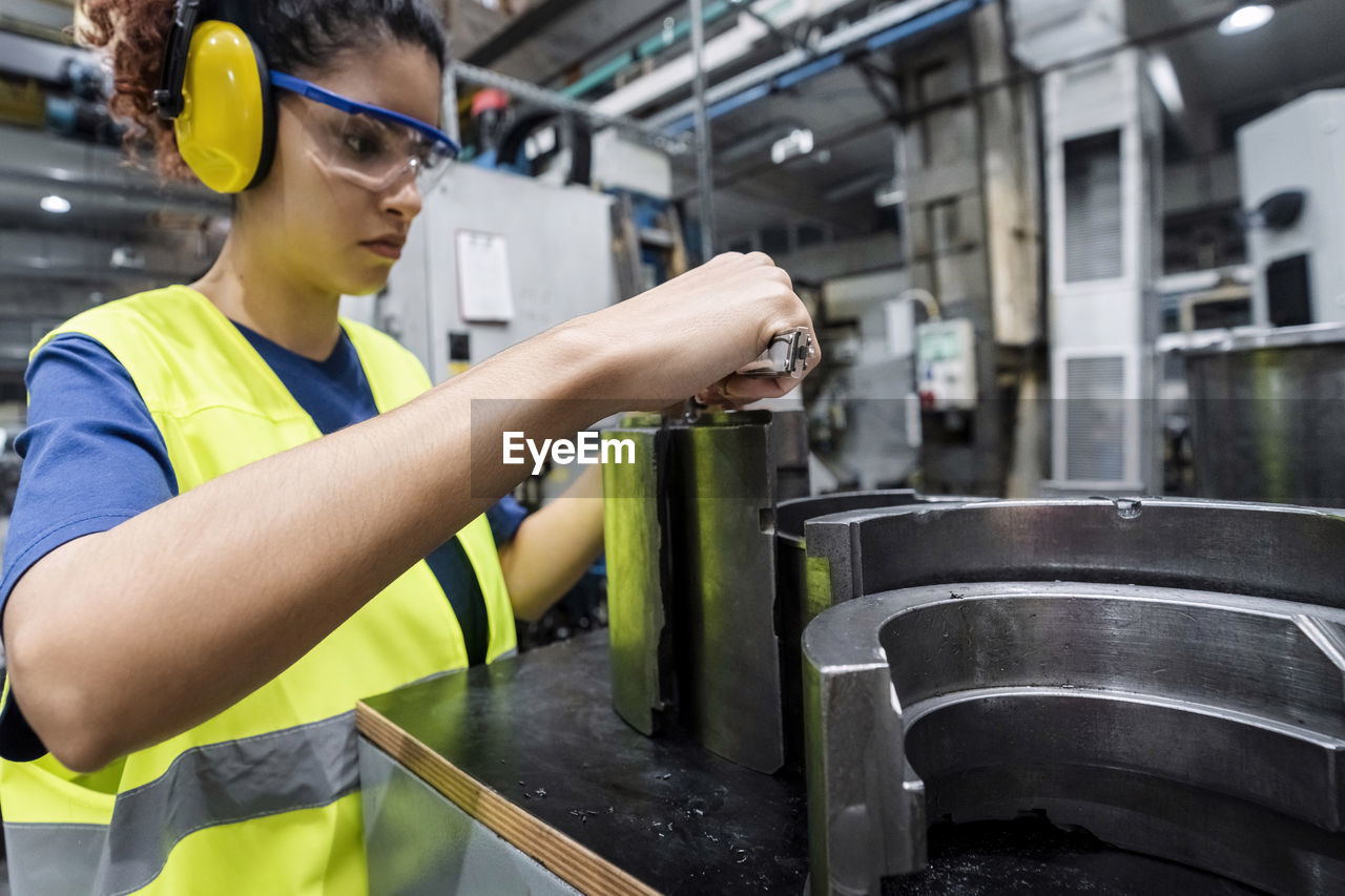 Engineer in protective workwear working in modern manufacturing industry