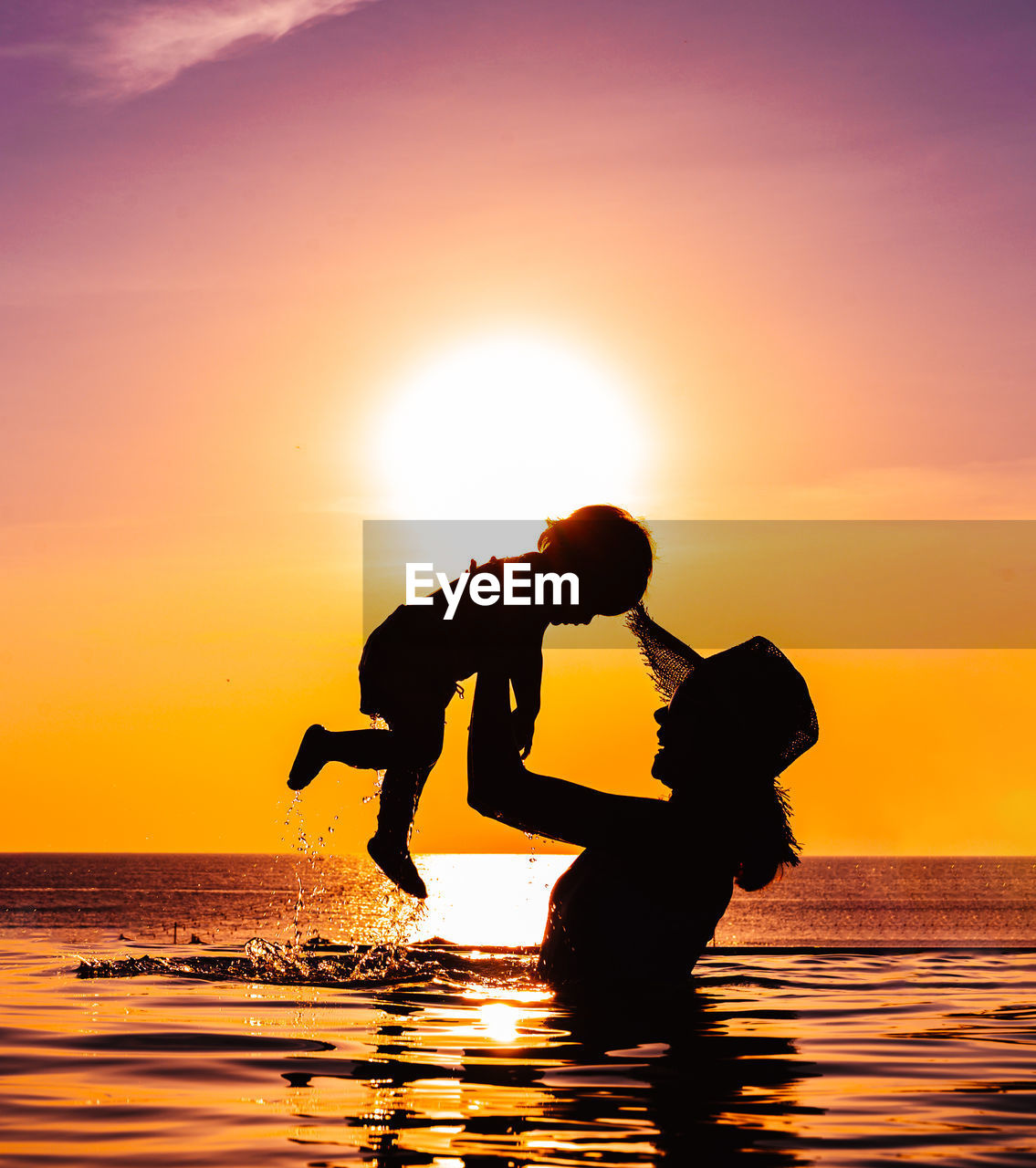 Silhouette people on sea against sky during sunset