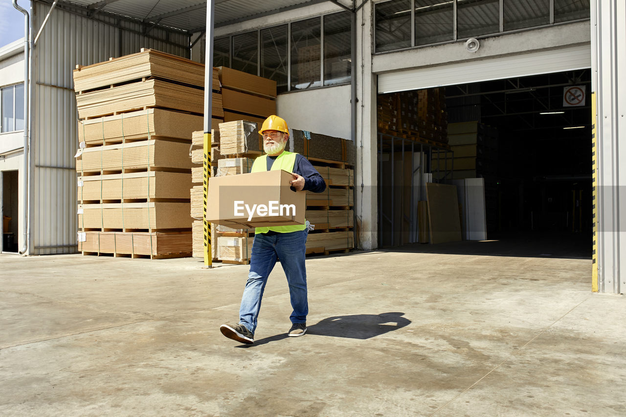 Worker carrying box on factory yard