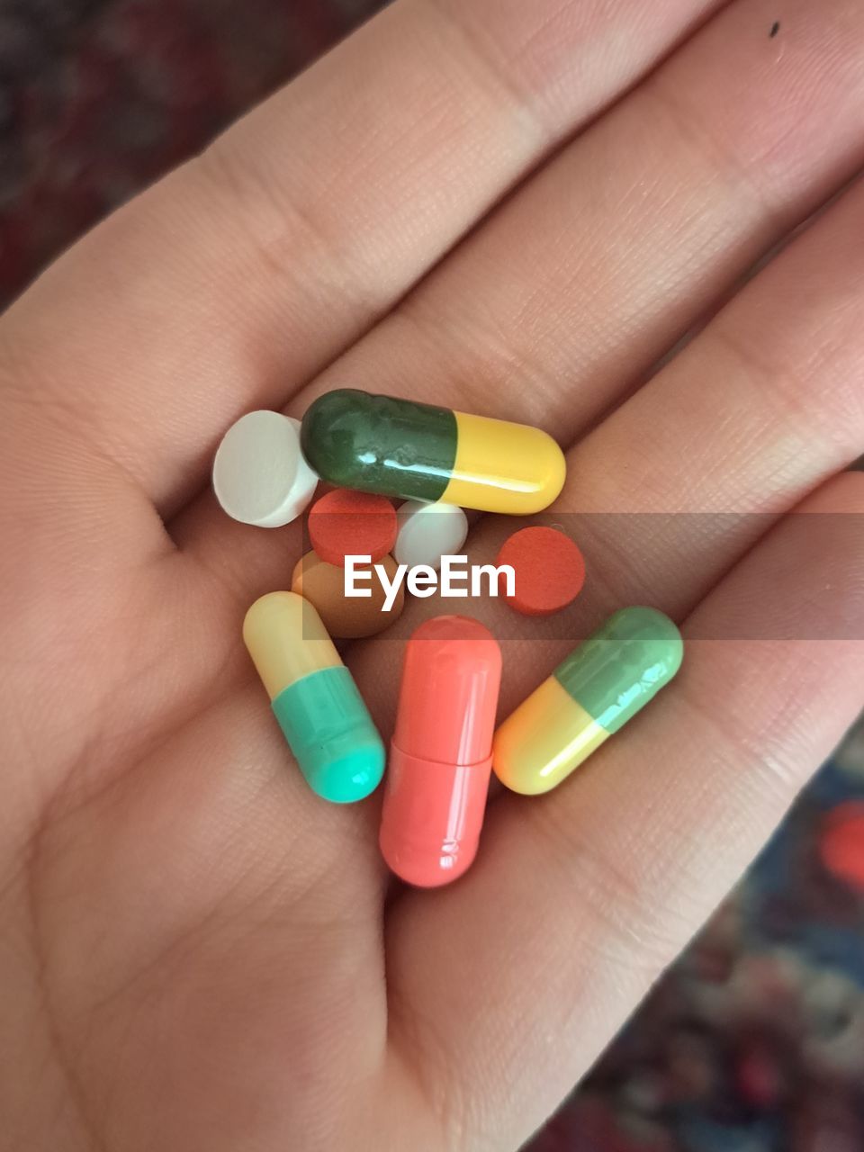 cropped hand of person holding pills