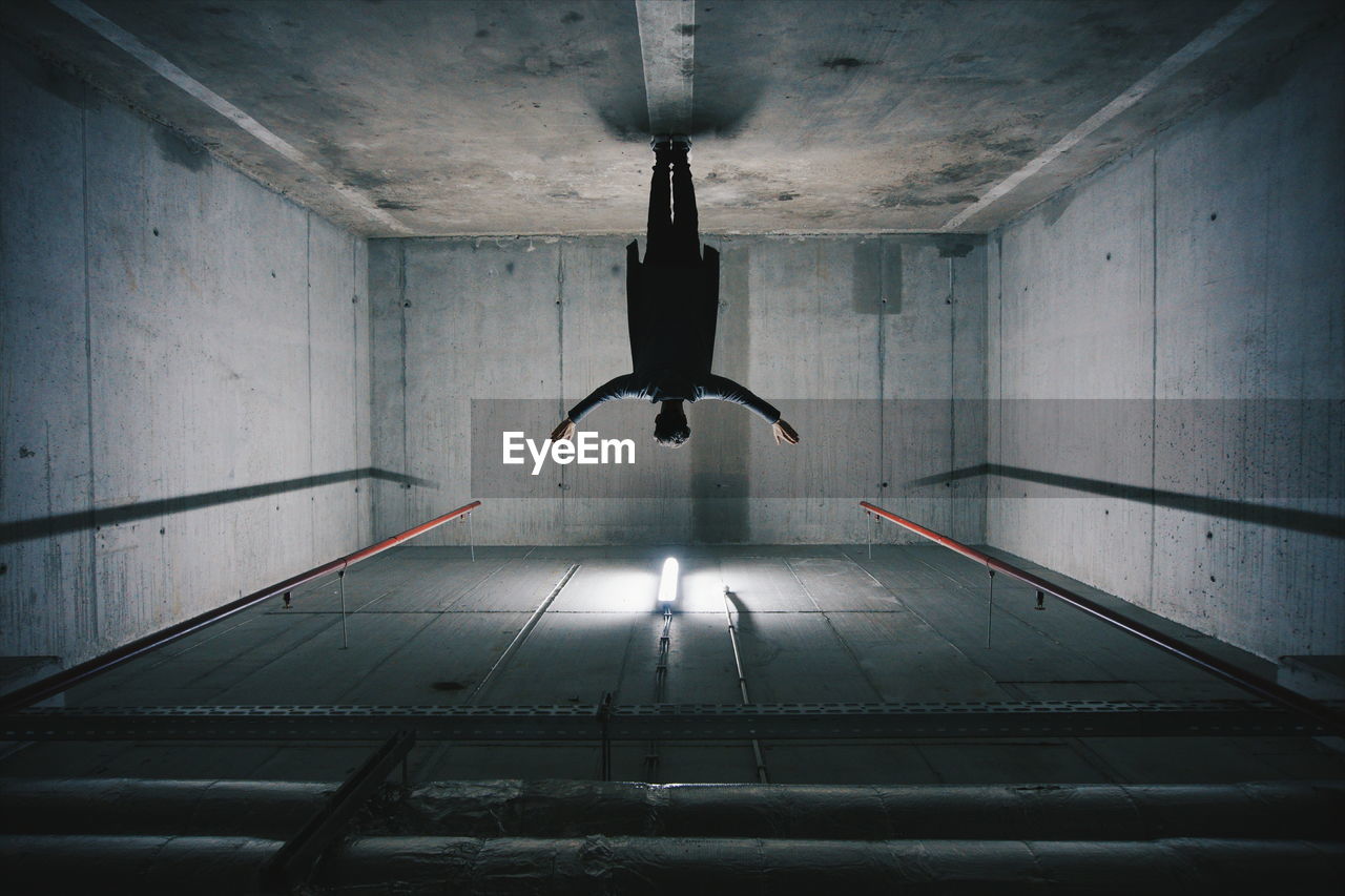 Rear view of man standing in empty warehouse