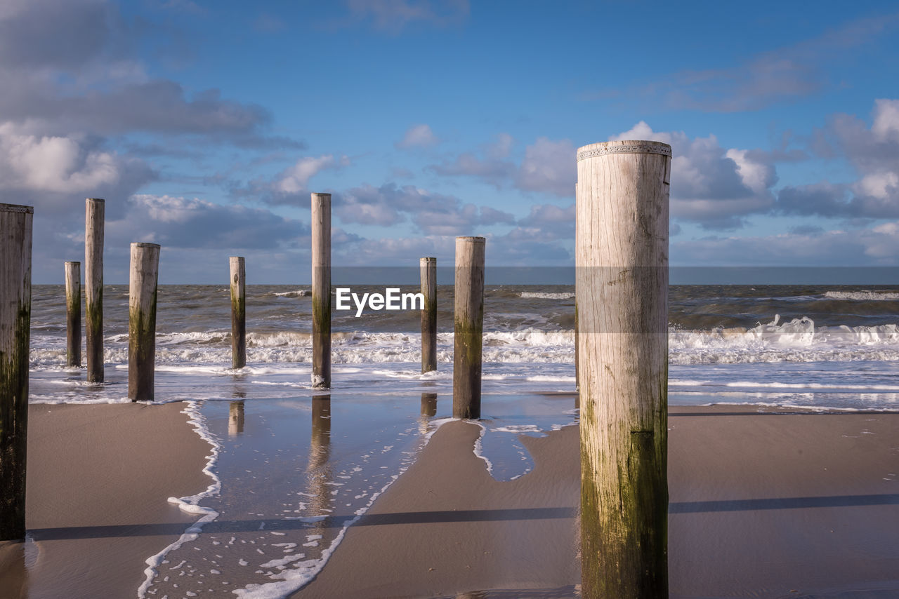 Petten, the netherlands. march 3, 2021. wooden poles at the beach, petten aan zee, the netherlands.