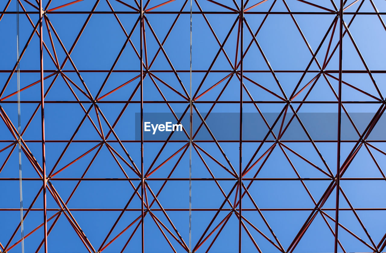 Image shows an abstract celling metal construction on blue sky background