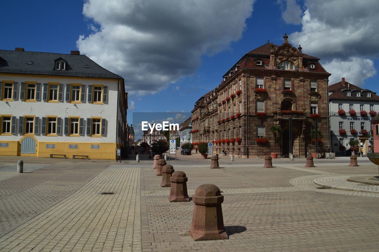 Street amidst buildings in town against sky