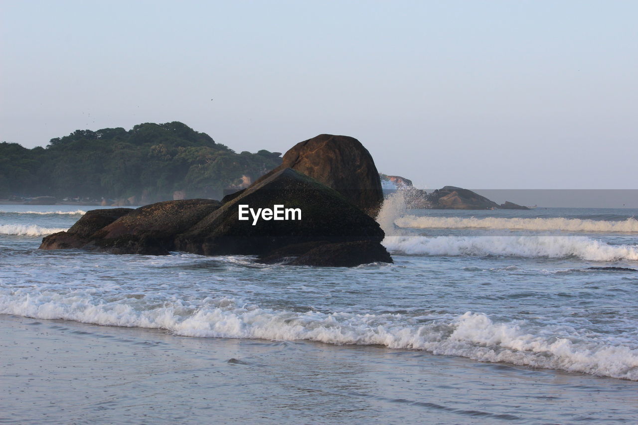 ROCKS ON SEA AGAINST CLEAR SKY