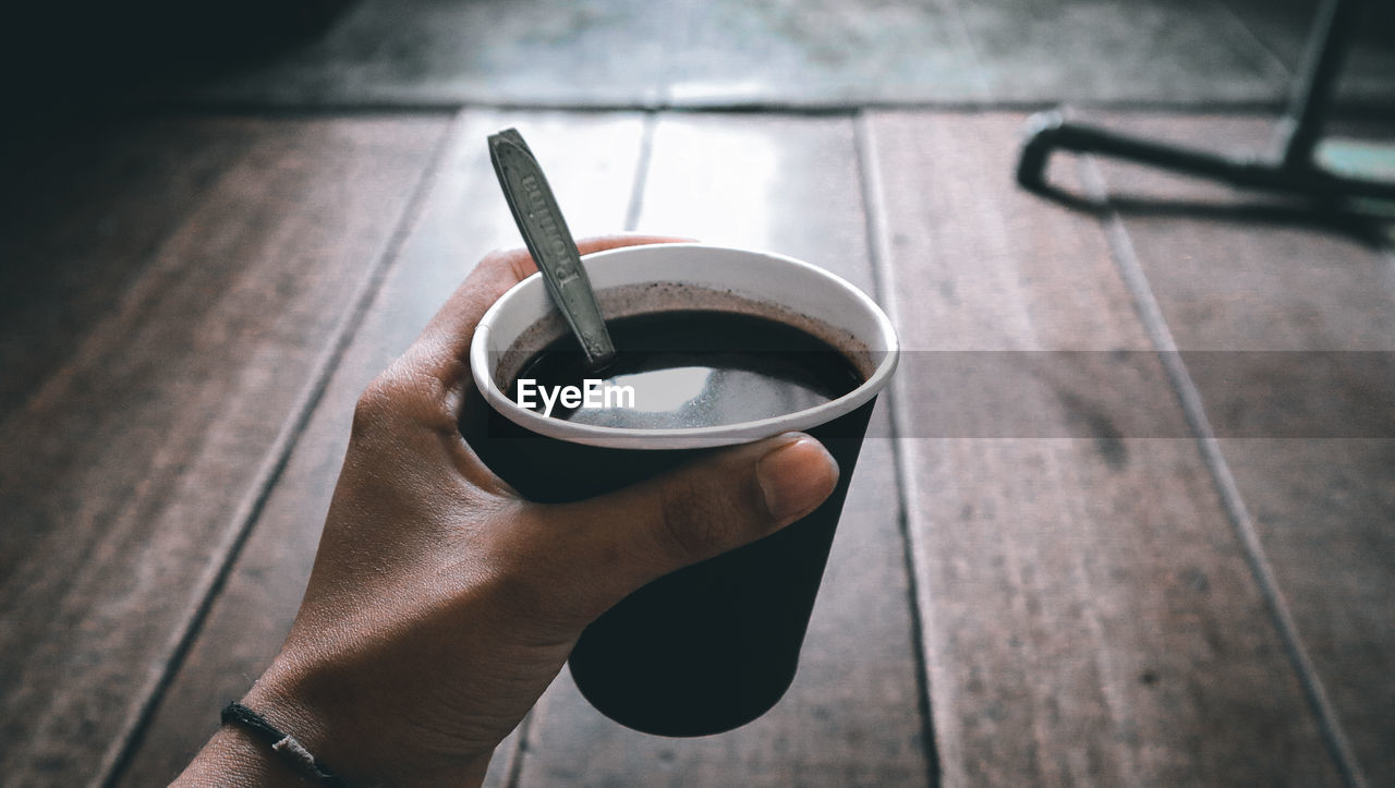 Close-up of hand holding coffee cup