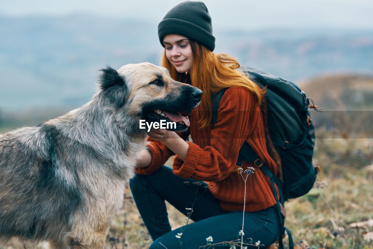 YOUNG WOMAN WITH DOG ON THE BACKGROUND