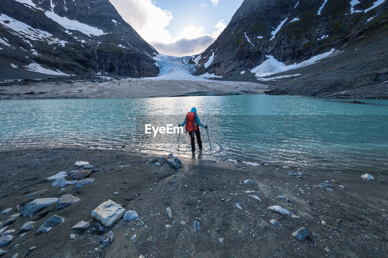 Rear view of person at lake during sunset