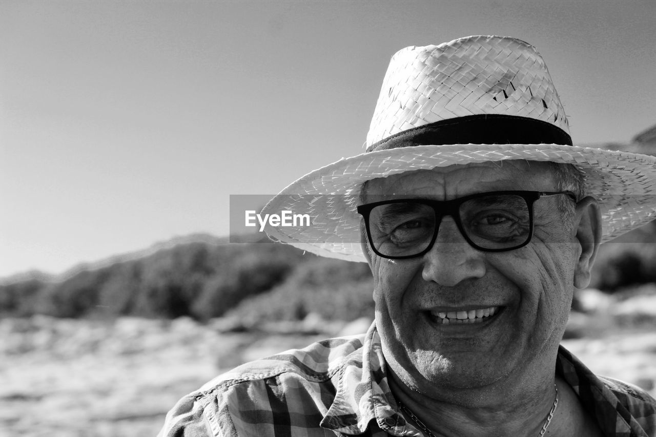 Close-up portrait of senior man against sky