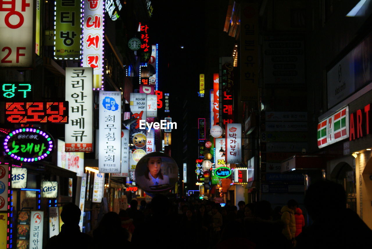 Illuminated advertisement in city at night