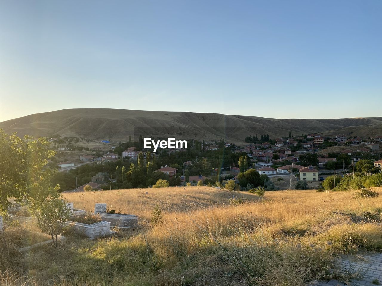 landscape, hill, environment, sky, plant, nature, scenics - nature, architecture, land, rural area, building, building exterior, natural environment, beauty in nature, no people, wilderness, built structure, tree, clear sky, grass, house, tranquility, plateau, day, outdoors, non-urban scene, residential district, tranquil scene, travel destinations, field, morning, travel, rural scene, blue, copy space, village, horizon, sunny, sunlight