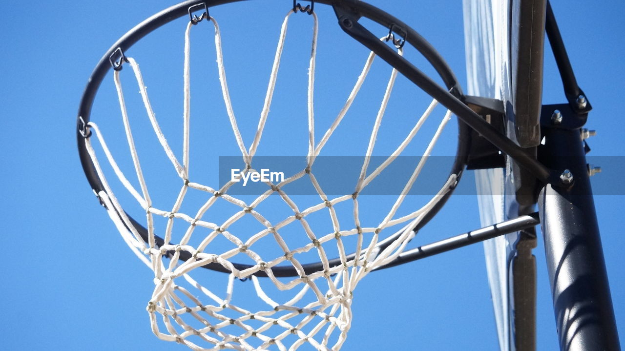 LOW ANGLE VIEW OF BASKETBALL HOOP AGAINST CLEAR SKY